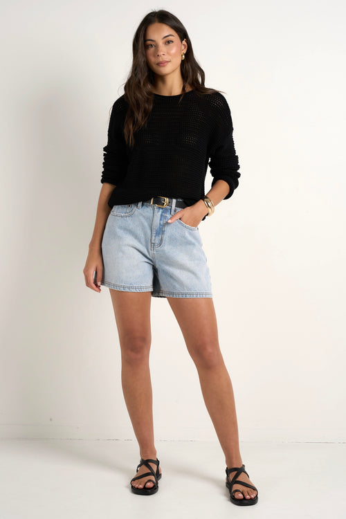 model wears blue denim shorts