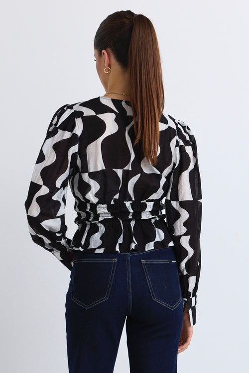 model wears a black and white print top