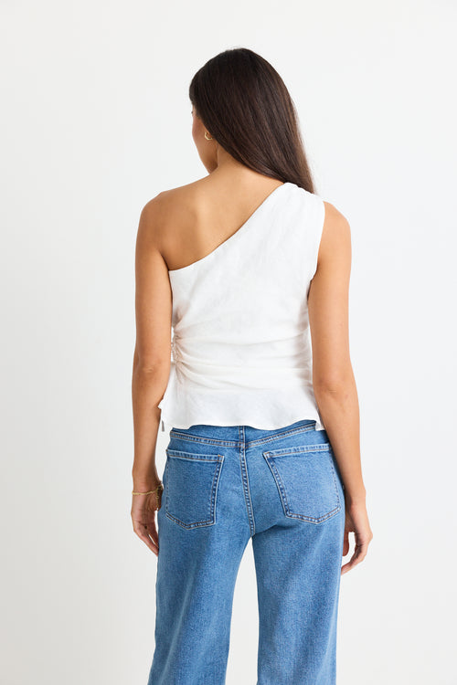 model is in a white top and blue jeans