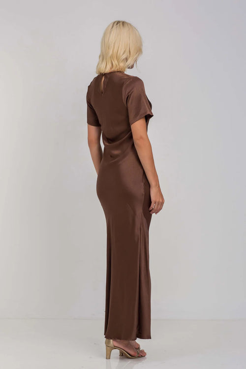 Model wears a chocolate brown short sleeve maxi dress with a side slit