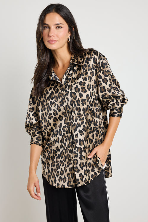 Woman wearing a leopard print satin shirt with a relaxed fit, paired with black satin pants for an effortlessly chic look.
