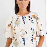 Woman wearing a floral blouse with a plain background