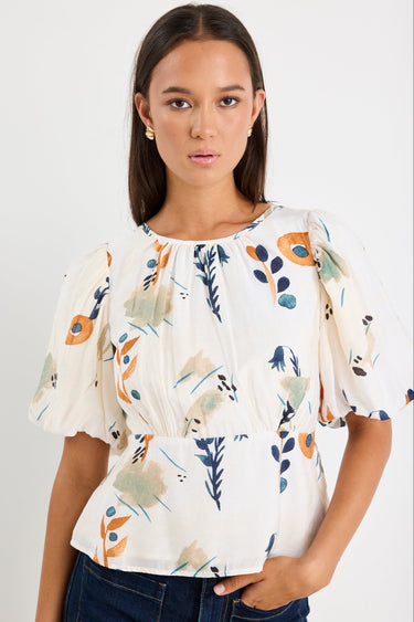 Woman wearing a floral blouse with a plain background