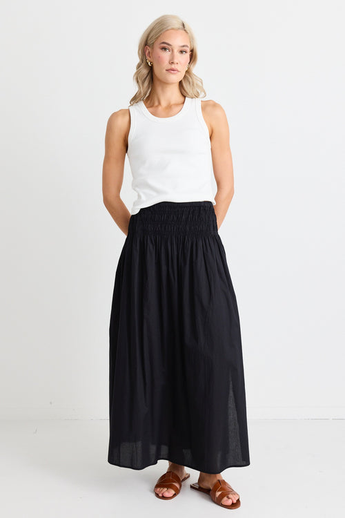 model wears white tank and black cotton maxi skirt