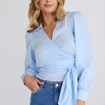 model wears a blue wrap shirt