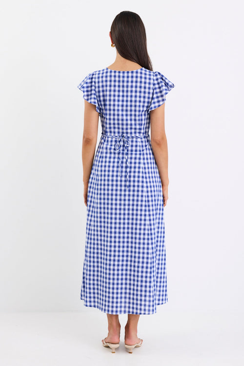 Woman wearing a blue and white checkered dress on a white background