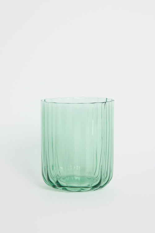Green glass tumbler on a white background