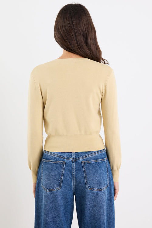 Person wearing a beige sweater and blue jeans on a white background
@col_pattern