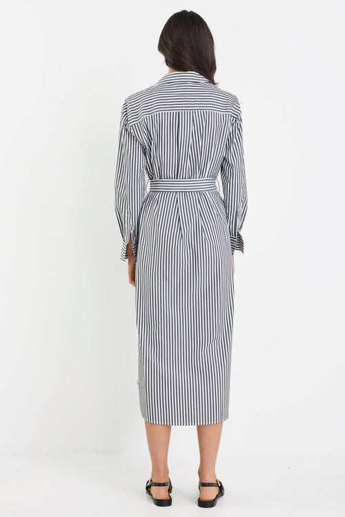 Woman wearing a black and white striped dress on a white background