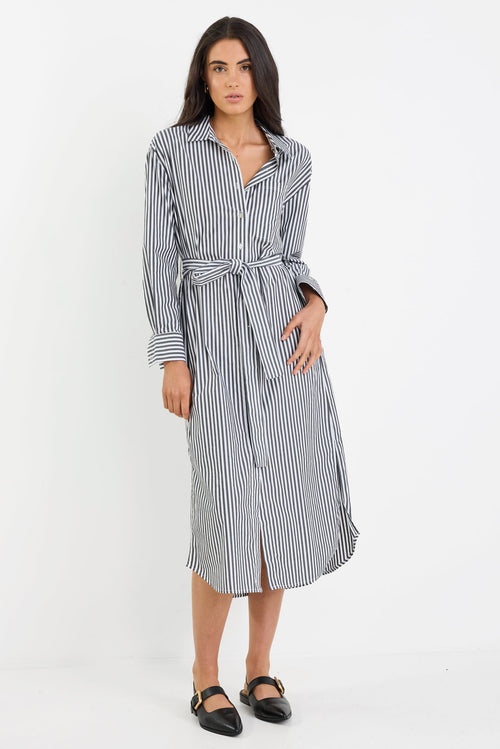 Woman wearing a black and white striped dress on a white background