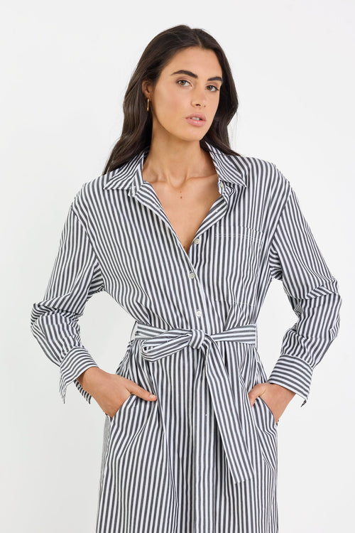 Woman wearing a black and white striped dress against a white background