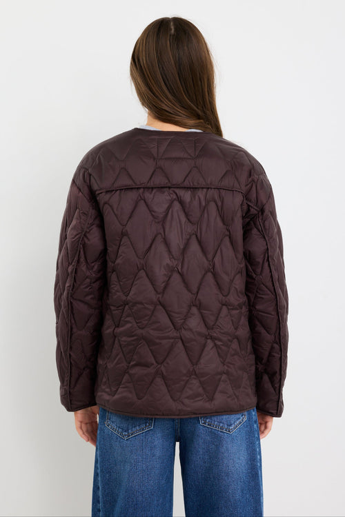 Person wearing a quilted jacket with a white background