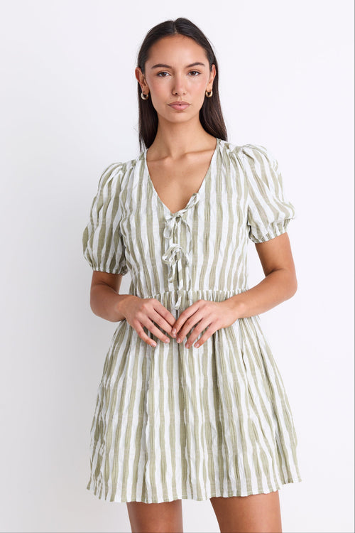 Model wearing a khaki striped puff sleeve mini dress with a V-neckline, puff sleeves, and a tie detail at the front.