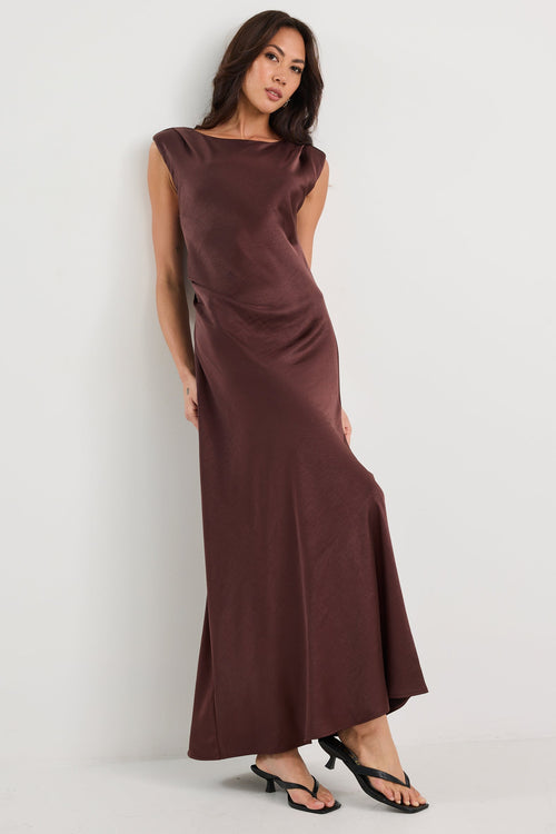 Woman wearing a brown dress against a white background