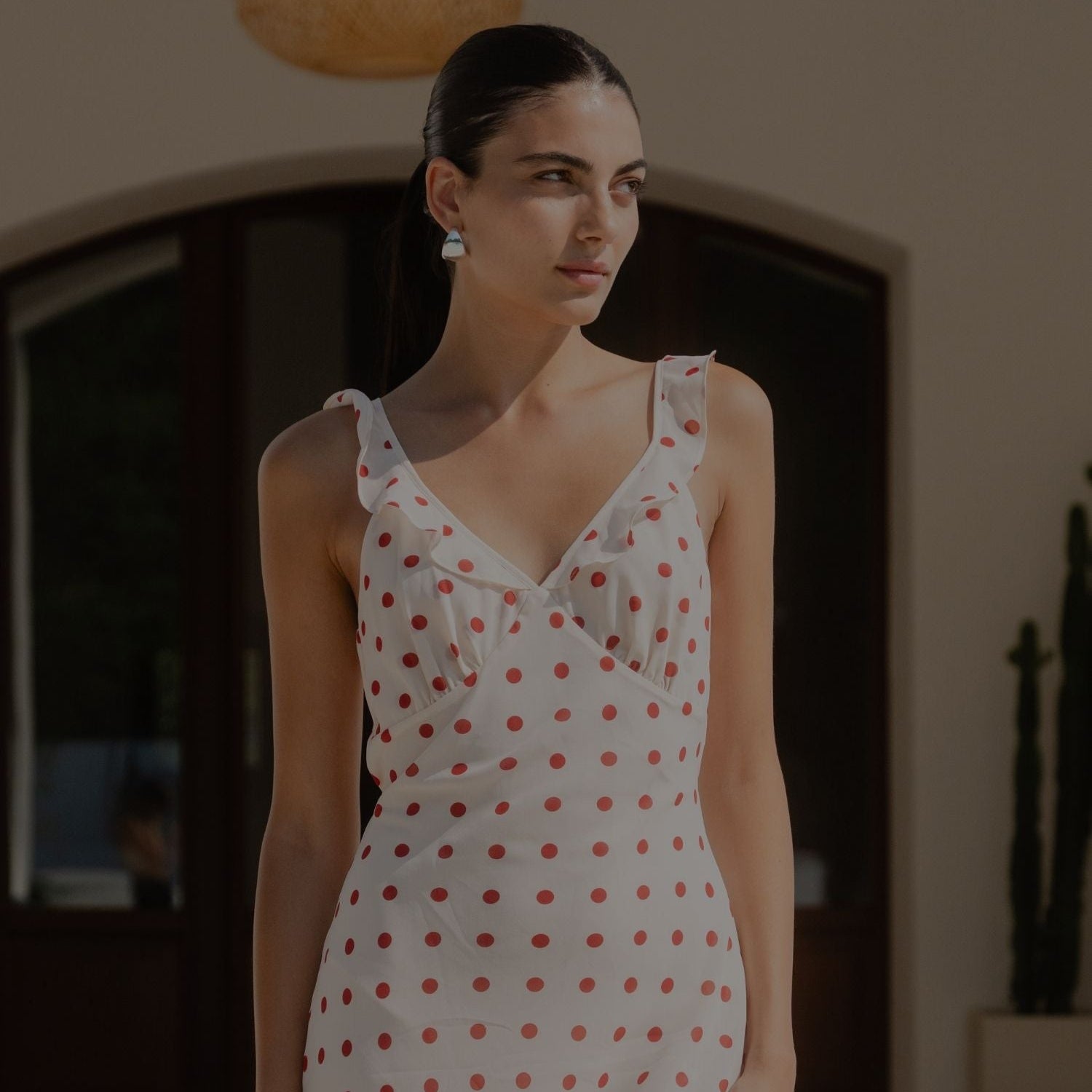 Woman wearing a white dress with red polka dots indoors