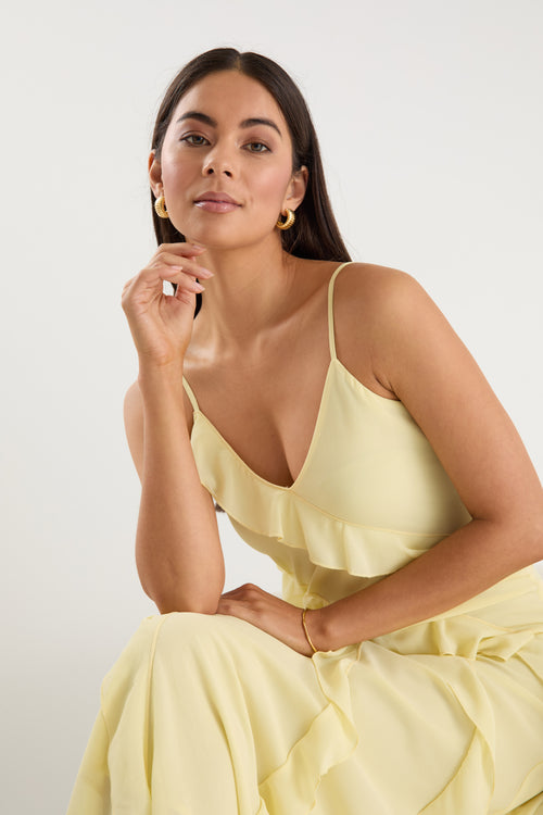 The model wears a yellow ruffle maxi dress