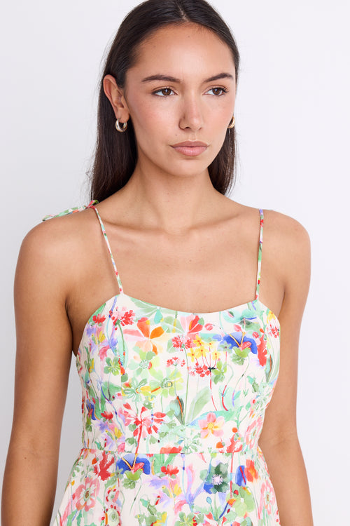Model wearing a floral strappy maxi dress with a tie detail and shirred back.