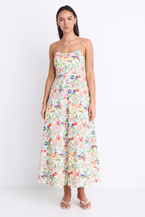 Model wearing a floral strappy maxi dress with a tie detail and shirred back.