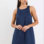 Woman wearing a navy blue sleeveless dress on a white background