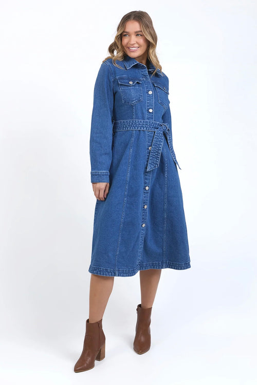 Model wears a midi blue denim dress with a tie waist and collar. 