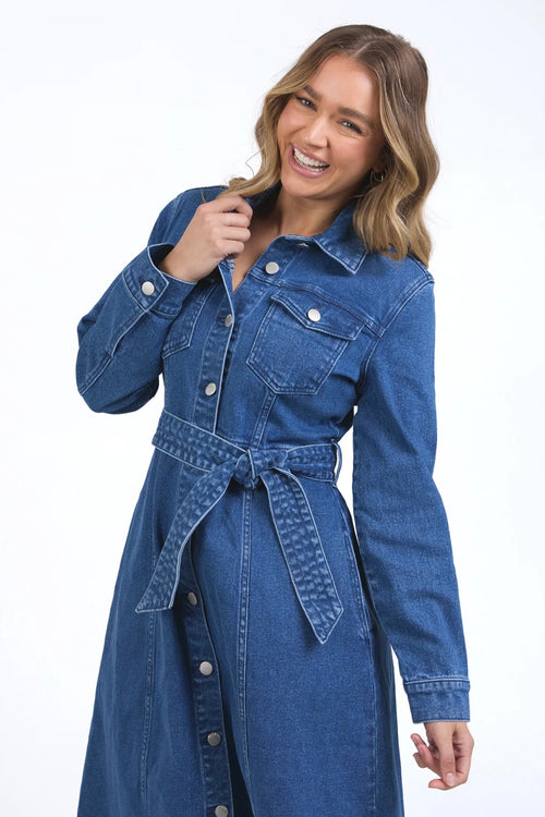 Model wears a midi blue denim dress with a tie waist and collar. 