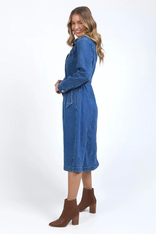 Model wears a midi blue denim dress with a tie waist and collar. 