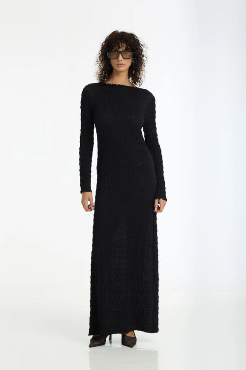 Woman wearing a black long-sleeve dress on a white background