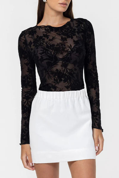 Black lace long-sleeve top and white skirt on a white background