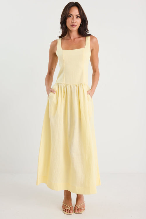 Woman wearing a light yellow dress on a white background