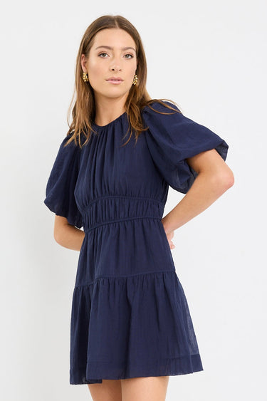 Woman wearing a navy blue dress on a white background