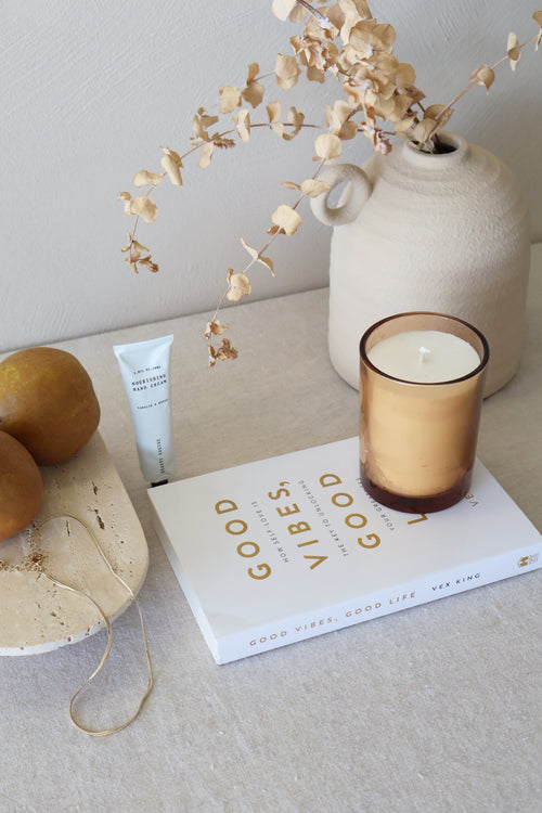 Good Vibes Good life book on a table with a candle and other homewares