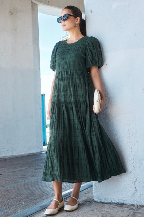 Model wears a forest green maxi dress