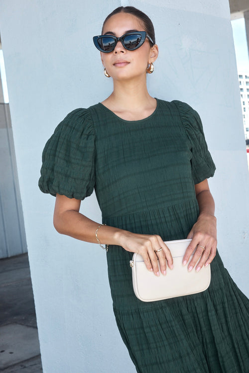 Model wears a forest green maxi dress