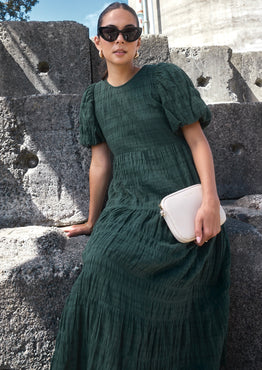 Model wears a forest green maxi dress