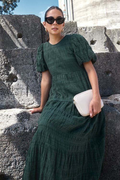 Model wears a forest green maxi dress