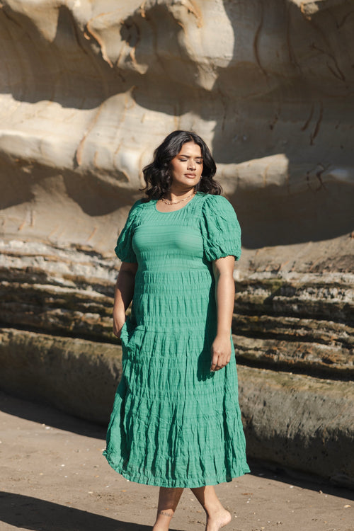 model wears a green maxi dress