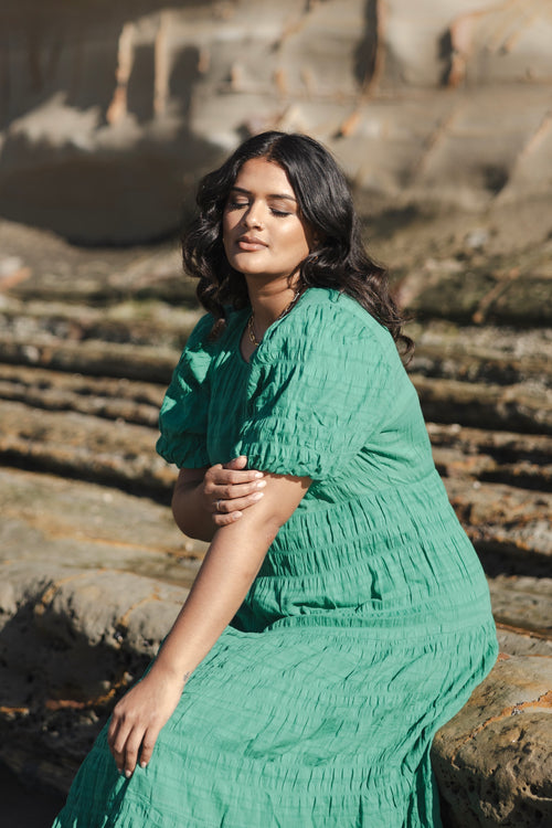 model wears a green maxi dress