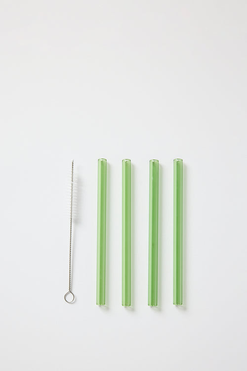 Set of green straws with a metal cleaning brush on a white background