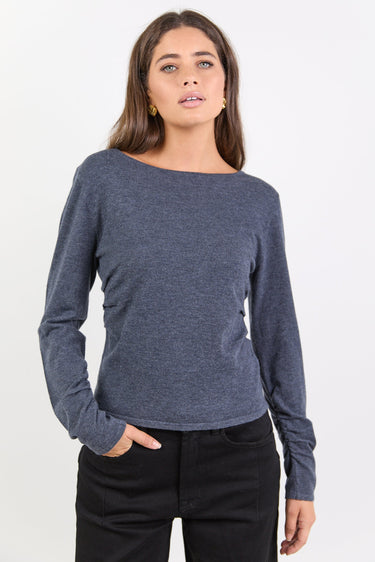 Woman wearing a charcoal top against a white background