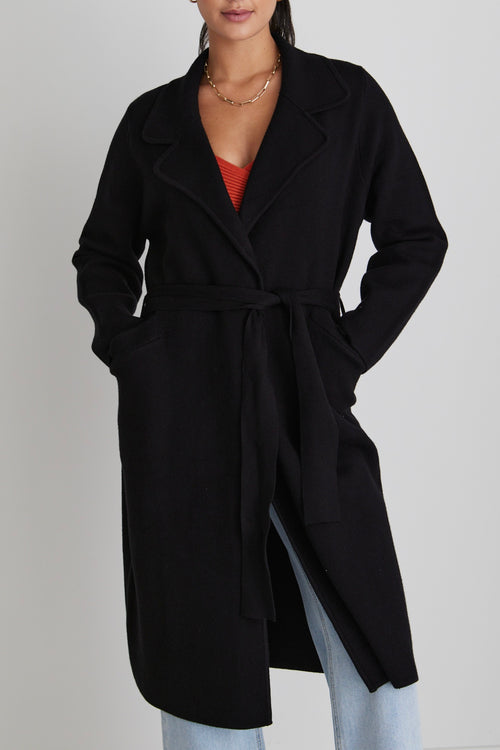 model wears a black coat