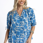 Woman wearing a blue and white floral blouse