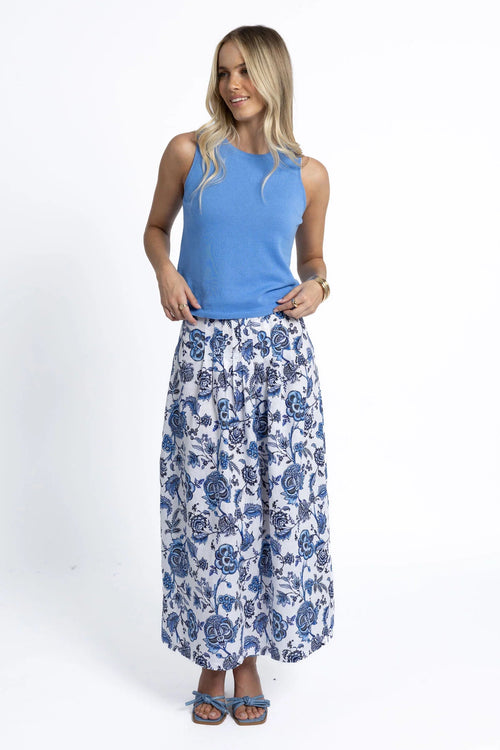 Woman wearing a blue knit and floral skirt