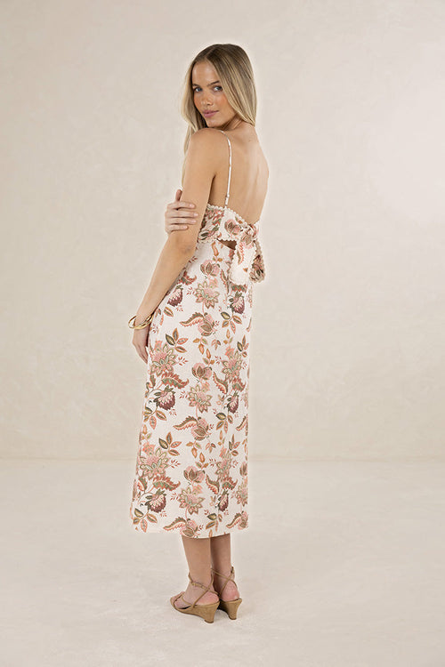 Woman wearing a floral dress on a plain background