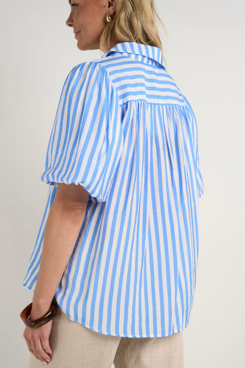 model wears a blue and white stripe shirt