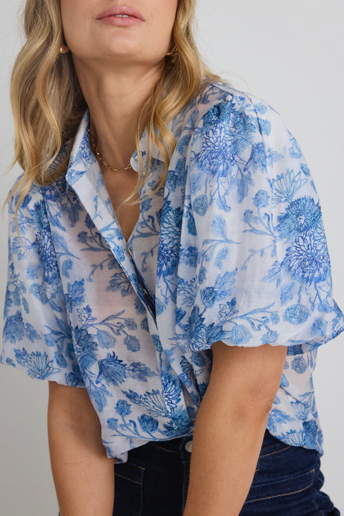 model wears a blue floral shirt 