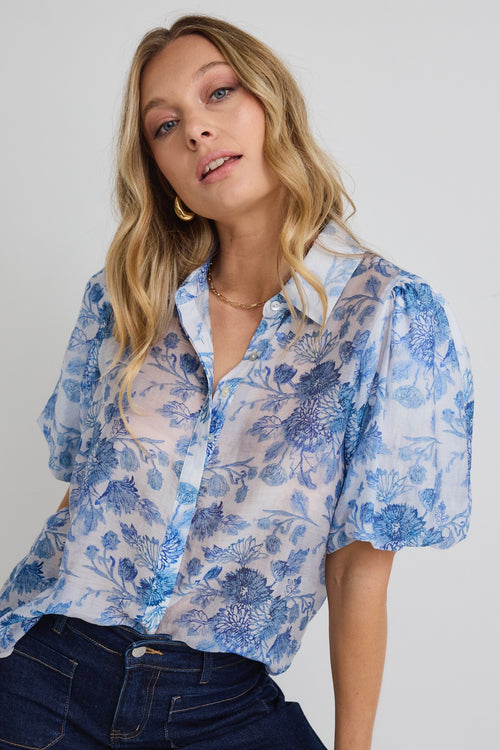 model wears a blue floral shirt 