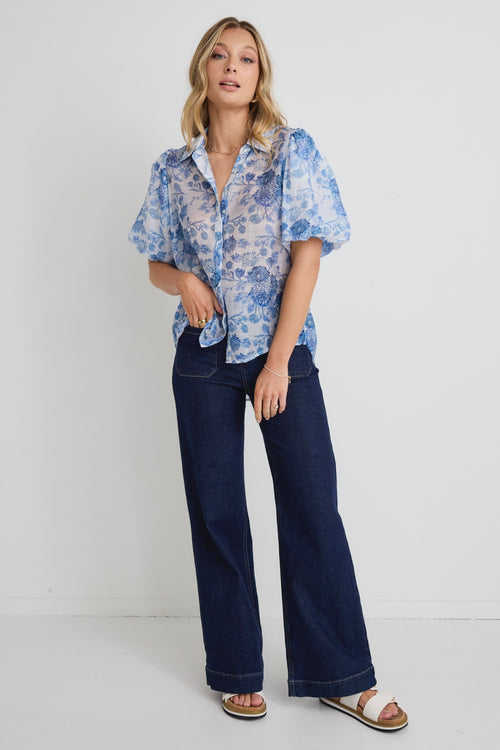 model wears a blue floral shirt 