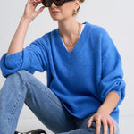 Model wears a blue jumper with jeans