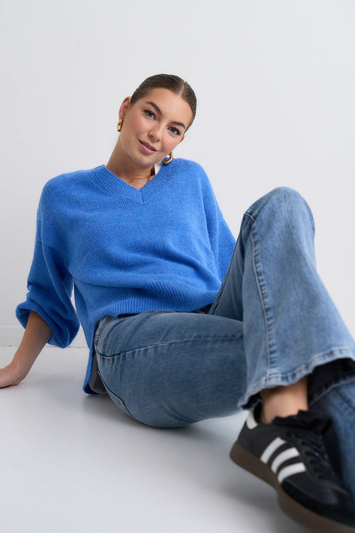 Model wears a blue jumper with jeans