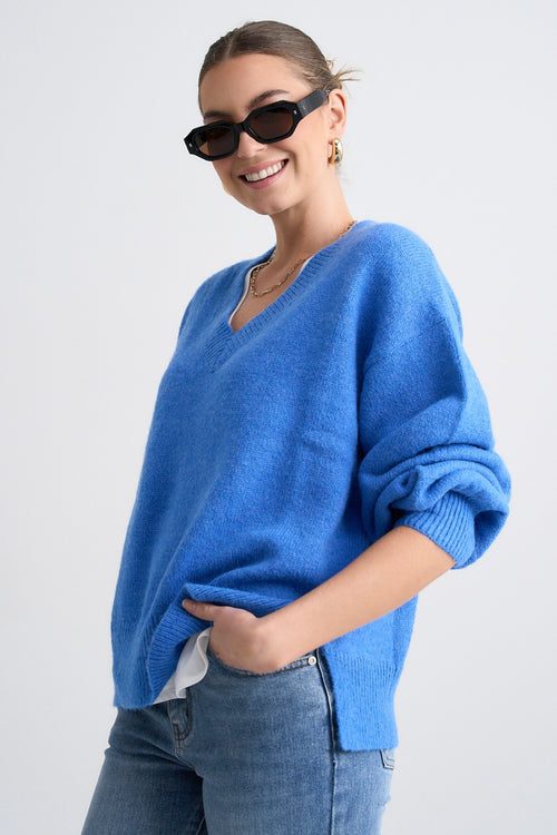 Model wears a blue jumper with jeans